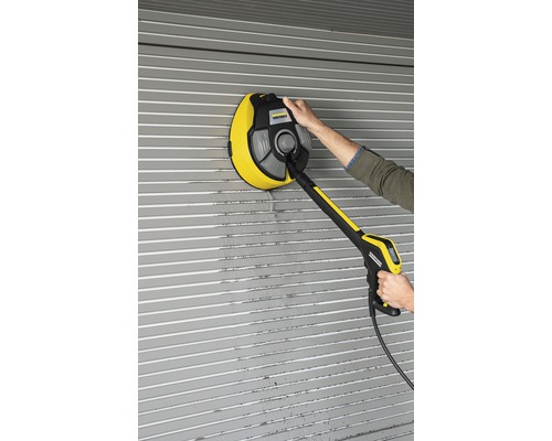 En person rengör en rullport med en roterande borste från Kärcher.