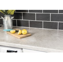 Köksbänk med skärbräda, citron och kniv framför kakel