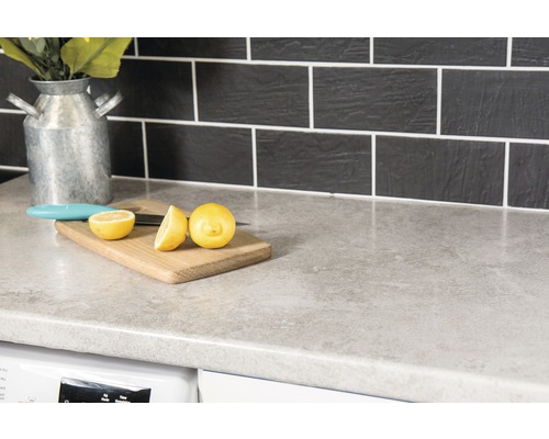 Köksbänk med skärbräda, citron och kniv framför kakel