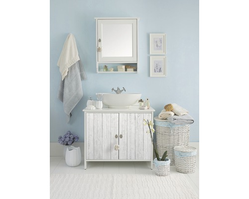 Badrumsensemble med tvättställsskåp, spegel, tillbehör och dekorationer för en ljus och vänlig atmosfär