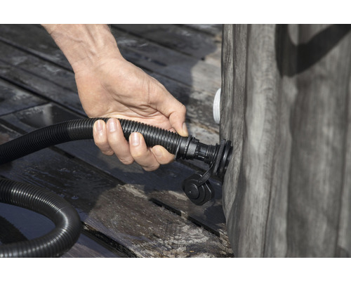 En person ansluter en slang till en pool.