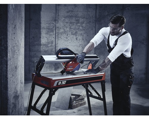 En man använder en kakelskärare TR 202 i en verkstad.