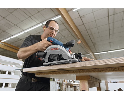 En man använder en Bosch handcirkelsåg för att såga trä.