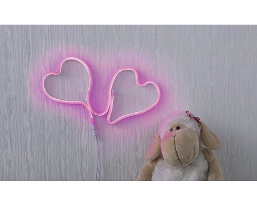 Dekoration med två neonhjärtan och gosedjur