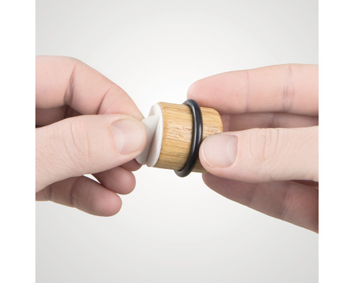 Vinkork av trä med gummitätning hålls av händer