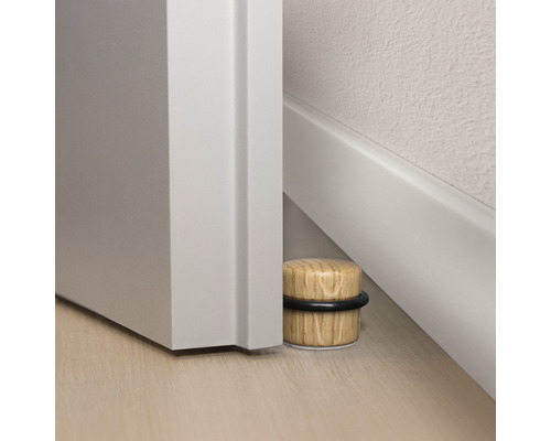 Dörrstopp av trä med gummiring bredvid en dörr