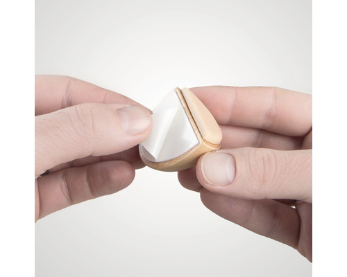 Händer tar bort skyddsfilm från en möbelglidare