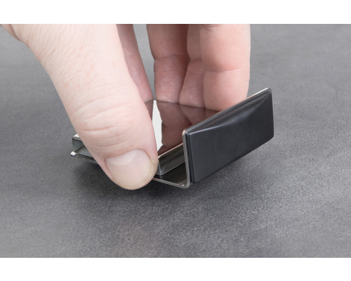 Person håller en metallprofil i handen