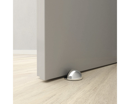 Dörrstopp i metall på golvet framför en dörr