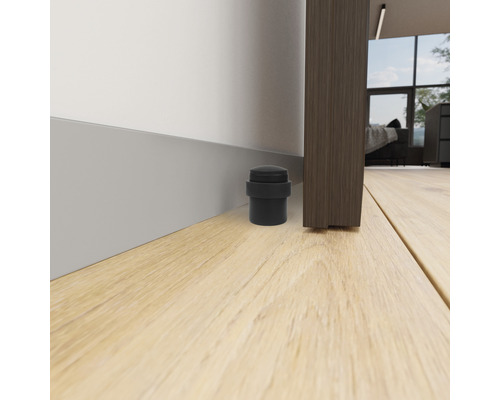 Dörrstopp av gummi på golvet bredvid en dörr