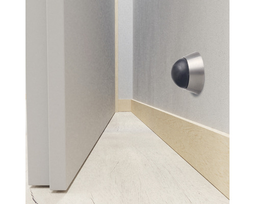 Väggmonterad dörrstopp med gummibuffert bredvid en dörr