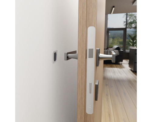 Öppen dörr med beslag i ett modernt vardagsrum.