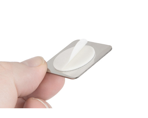 Metallskylt med självhäftande dyna i handen