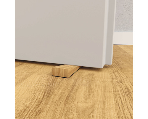 Dörrstopp i trä under en dörr på trägolv