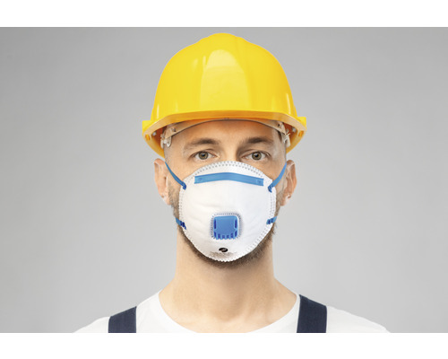 Hantverkare med andningsskyddsmask och skyddshjälm