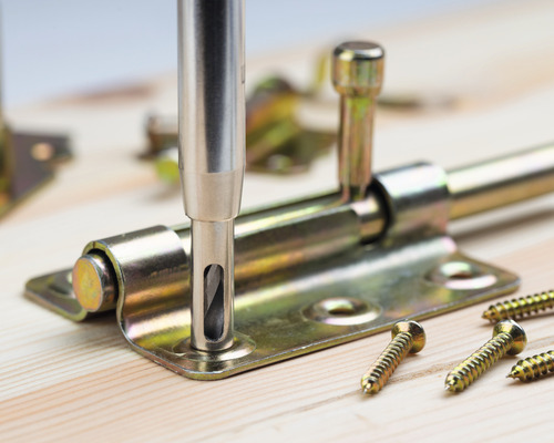 Dörrreglar av metall monterade med skruvar på trä