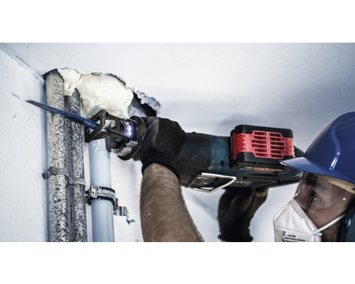 En person sågar ett rör med en tigersåg.