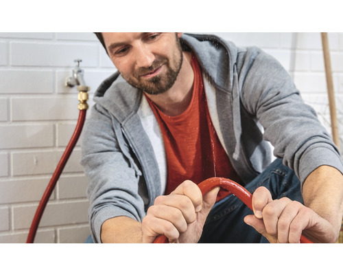 Man reparerar läckande vattenrör