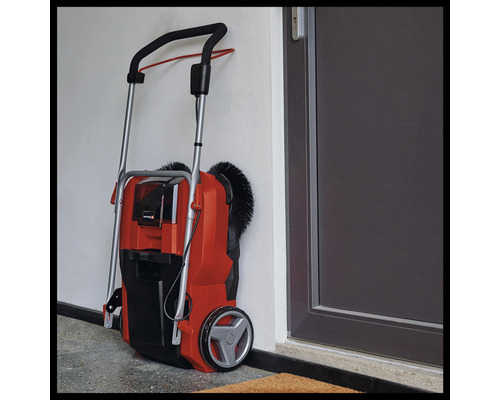 Sopmaskin för utomhusbruk lutad mot en vägg