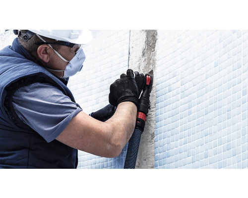 Hantverkare med personlig skyddsutrustning som arbetar med bearbetning av kakelfogar