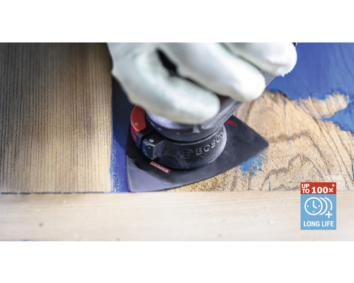 En man med handskar använder ett slipverktyg på en träbit för att ta bort färg. Bosch logotyp.