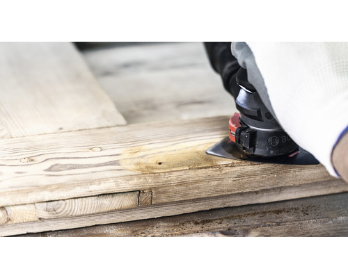 Hantverkare slipar trä med en multislipmaskin.