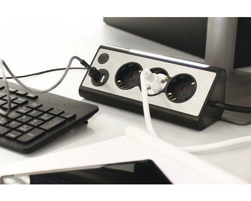 Grenuttag med USB-port och anslutna enheter på ett skrivbord