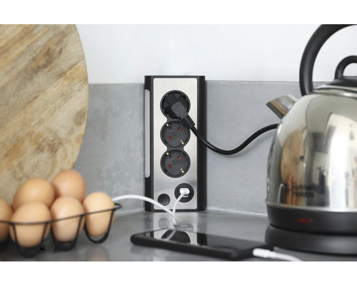 Grenuttag med USB-port på en köksbänk med ägg och vattenkokare.