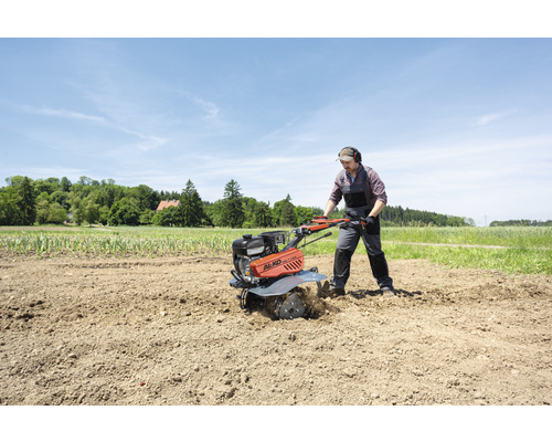 Man arbetar med en AL-KO jordfräs på ett fält.