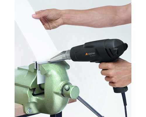 Varmluftspistol som värmer upp ett arbetsstycke i ett skruvstäd