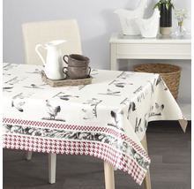 Bord med en duk med kycklingmotiv och en kant med ett hundtandsmönster.