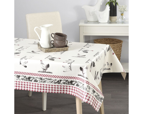 Bord med en duk med kycklingmotiv och en kant med ett hundtandsmönster.