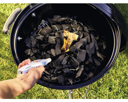 Tända kol i en grill med en tändare