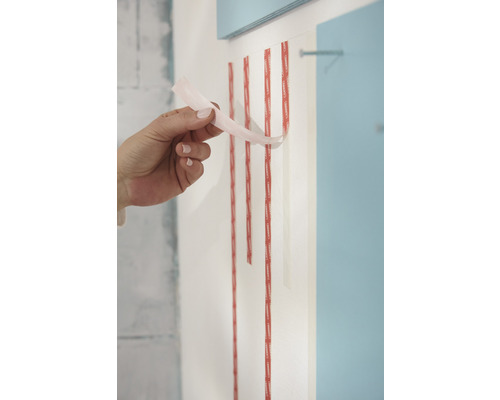 Applicering av dubbelsidig monteringstejp på en vägg.