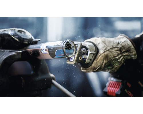 Ett rör som är fastspänt i ett skruvstäd skärs med en tigersåg