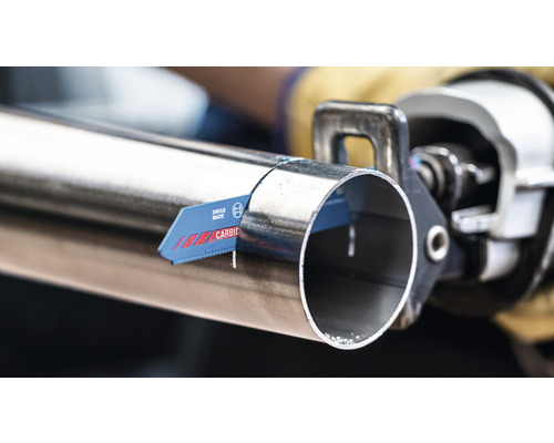 En metallsåg skär ett metallrör.