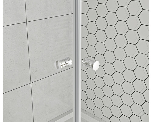 Detaljbild av en duschkabin med glasväggar och handtag mot en bakgrund av hexagonala plattor