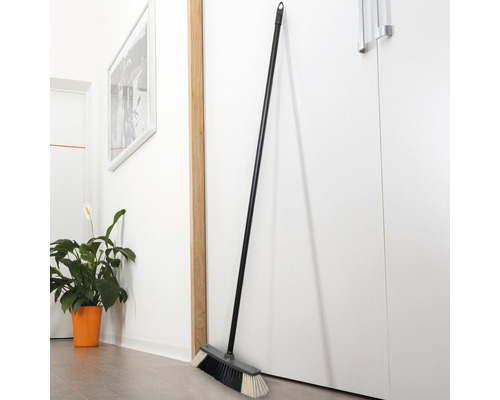Kvast med skaft, lutad mot en dörr