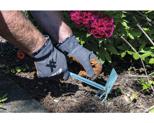 Trädgårdsarbete med en trädgårdshacka och handskar