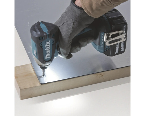 Makita logotyp. Slagskruvdragare som arbetar på en metallbit på en träskiva.