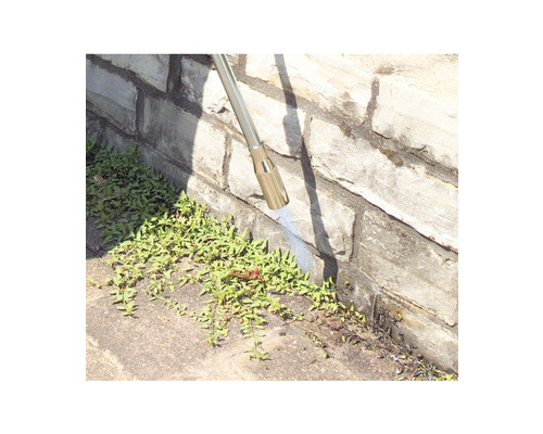 Ogräsbekämpning på en stenmur med en ogräsbekämpare