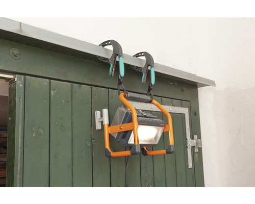 LED-strålkastare, upphängd med klämmor på en dörr