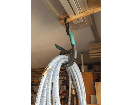 En transparent vattenslang hänger i en klämma för förvaring.