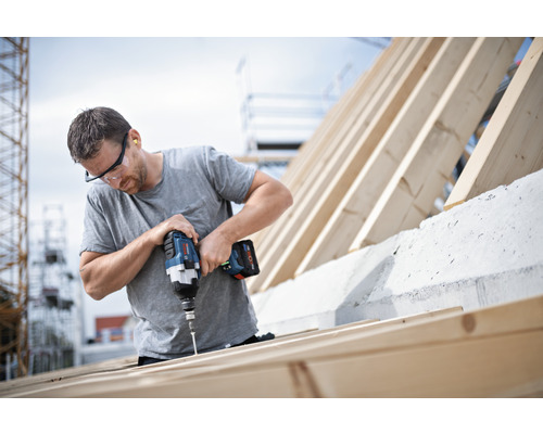 En hantverkare fäster skruvar i en träram med en sladdlös skruvdragare.