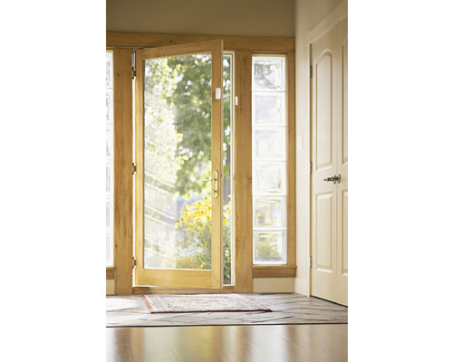 Entré med öppen glasdörr, glasblock och matta på golvet.