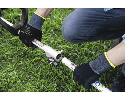 Montering av en motorröjsåg av en person med arbetshandskar i trädgården