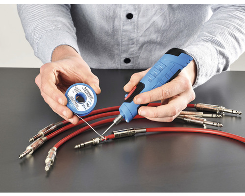 Person lödar kablar med lödkolv och lödtenn