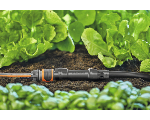 Gardena anslutningsstycke med två trädgårdsslangar i rabatten