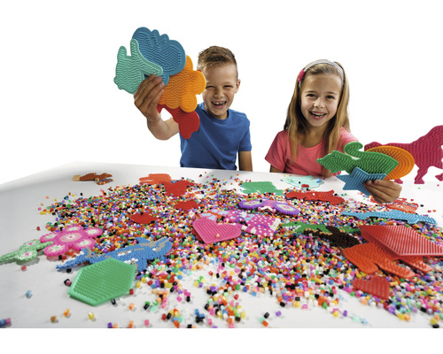 Barn leker med pärlplattor och pärlor på bordet