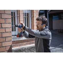 Man borrar i tegelvägg med batteridriven skruvdragare
